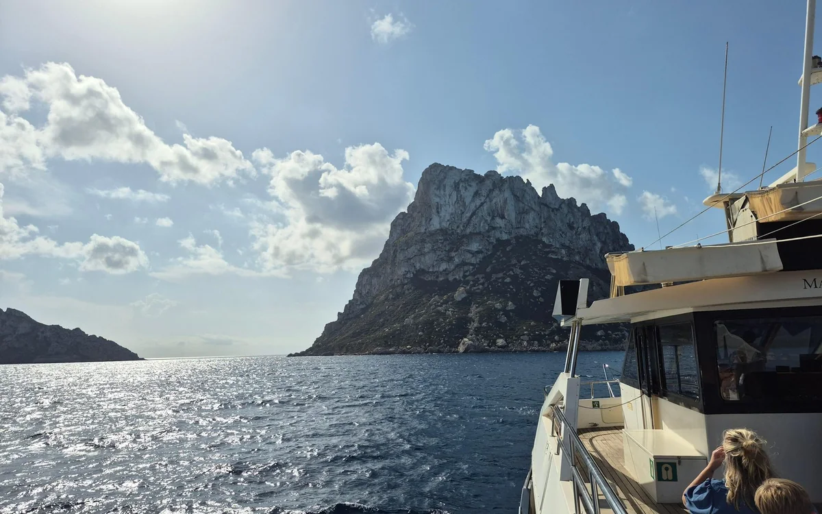 The rock of Es Vedrà rising from the sea, seen from the deck of a boat
